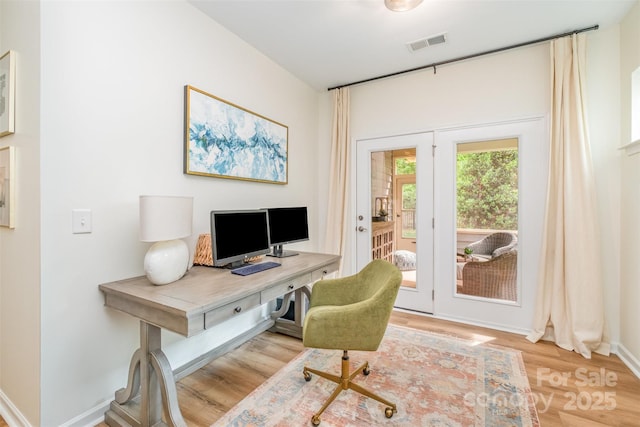 office area featuring baseboards, wood finished floors, and visible vents