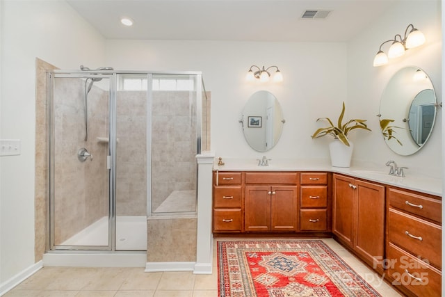 bathroom featuring tile patterned floors, a sink, and a stall shower