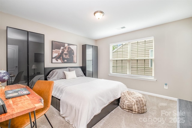 carpeted bedroom featuring visible vents and baseboards