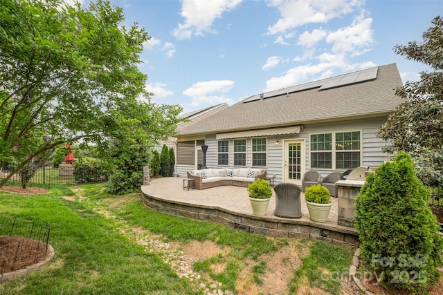 back of property featuring an outdoor living space, a patio area, fence, a yard, and solar panels