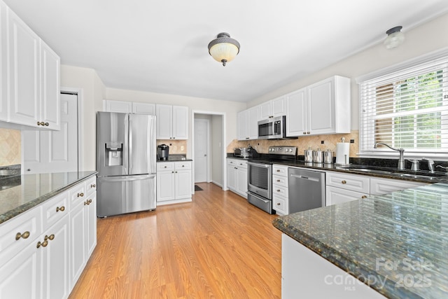 14812 Stonegreen Ln, Huntersville, NC 28078 - kitchen with a sink, white cabinets, light wood-type flooring, backsplash, and appliances with stainless steel finishes