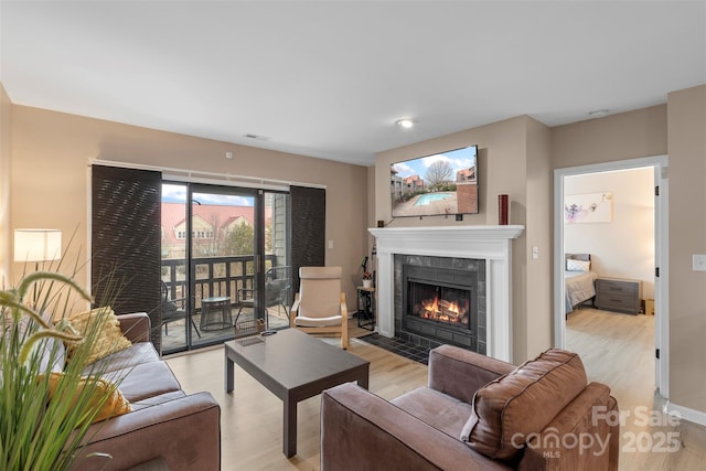 9029 J M Keynes Dr Unit 63, Charlotte, NC 28262 - living area featuring a tiled fireplace and light wood-style flooring