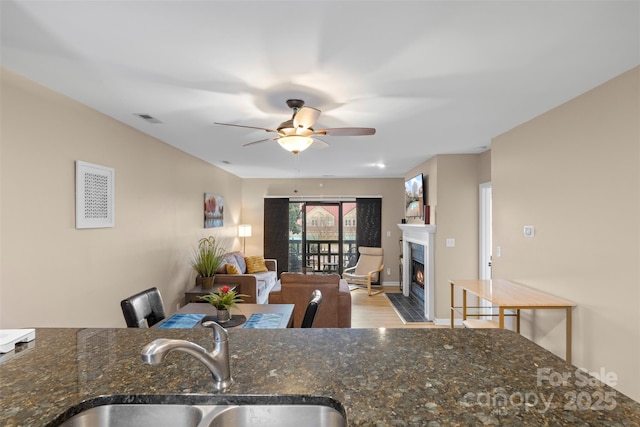 9029 J M Keynes Dr Unit 63, Charlotte, NC 28262 - kitchen with a fireplace with flush hearth, a sink, visible vents, wood finished floors, and ceiling fan