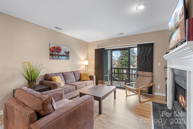 9029 J M Keynes Dr Unit 63, Charlotte, NC 28262 - living area with a tile fireplace, visible vents, baseboards, and light wood-type flooring