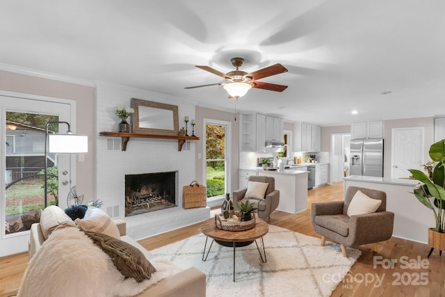 1607 Old Lawyers Rd, Marshville, NC 28103 - living area with healthy amount of natural light, light wood-style floors, a ceiling fan, a fireplace, and ornamental molding
