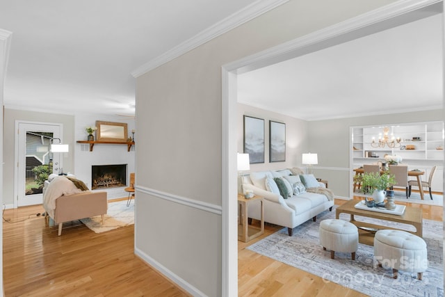 1607 Old Lawyers Rd, Marshville, NC 28103 - living area featuring wood finished floors, a fireplace, crown molding, a chandelier, and baseboards