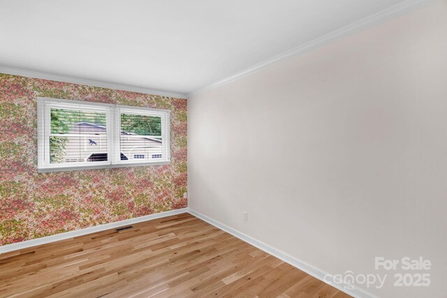 1607 Old Lawyers Rd, Marshville, NC 28103 - empty room featuring wallpapered walls, baseboards, light wood-type flooring, and crown molding