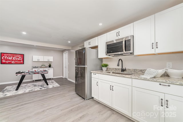 221 Belton Ave, Mount Holly, NC 28120 - kitchen with stainless steel appliances, light wood-style floors, white cabinets, light stone counters, and recessed lighting