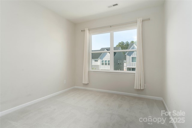 spare room featuring baseboards, carpet, and visible vents
