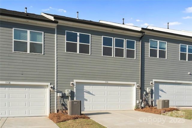view of property exterior with central AC, driveway, and a garage