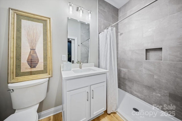 360 N Broad St, Waxhaw, NC 28173 - bathroom with vanity, wood finished floors, a tile shower, and toilet