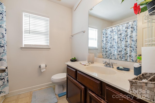 full bath featuring baseboards, a shower with curtain, toilet, and vanity