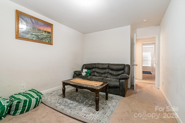 carpeted living area featuring baseboards