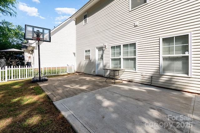 rear view of property featuring a patio and fence