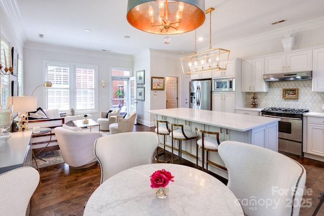 6231 Wakehurst Rd, Charlotte, NC 28226 - kitchen with an inviting chandelier, dark wood-type flooring, stainless steel appliances, and under cabinet range hood