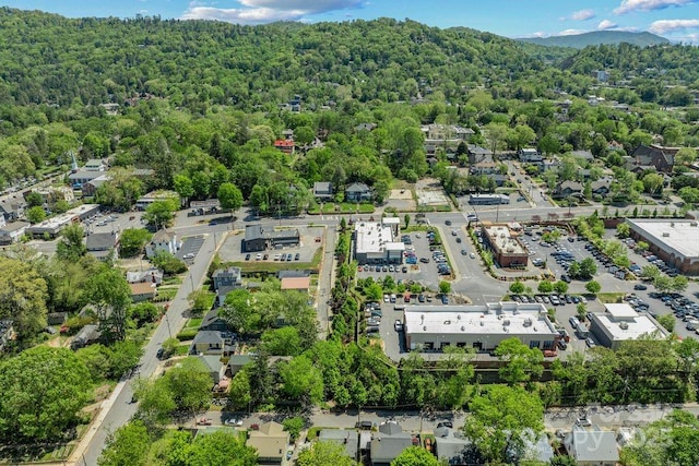 drone / aerial view featuring a wooded view and a mountain view