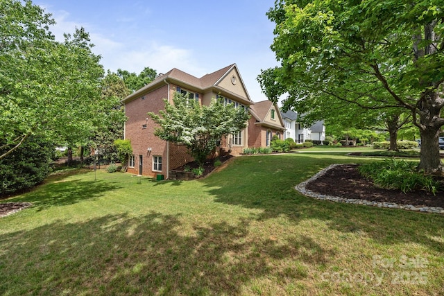 view of side of property featuring a lawn and brick siding