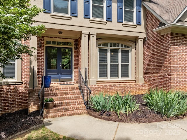 entrance to property featuring brick siding and french doors