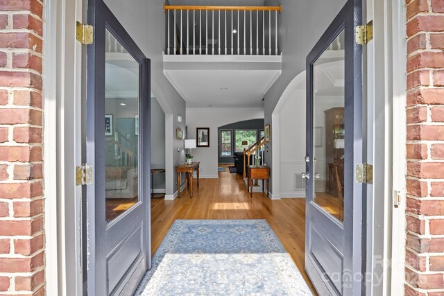 entryway featuring visible vents, arched walkways, baseboards, and wood finished floors