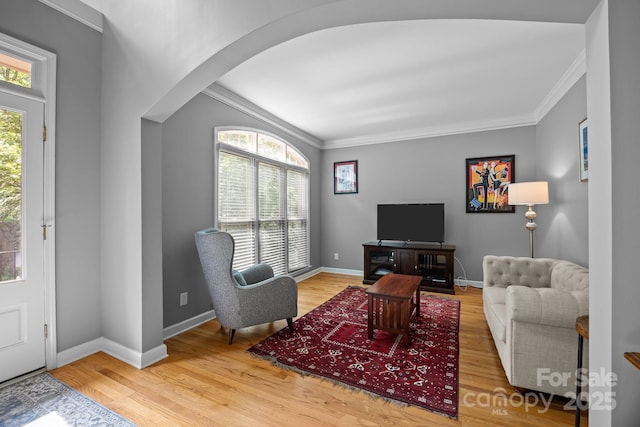 living room with crown molding, plenty of natural light, and wood finished floors