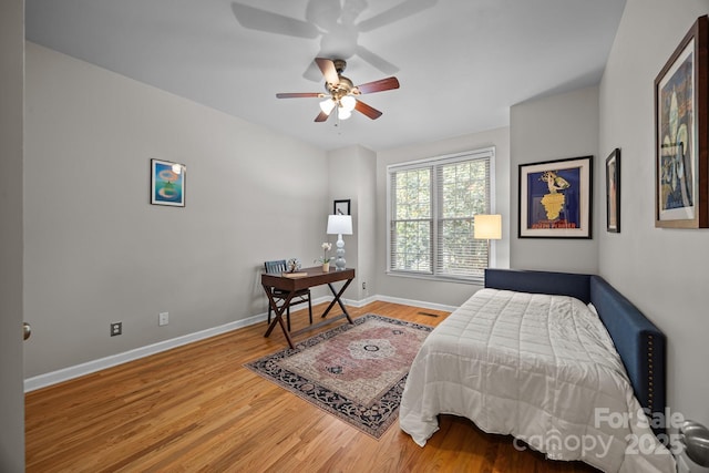 bedroom with baseboards, ceiling fan, and wood finished floors