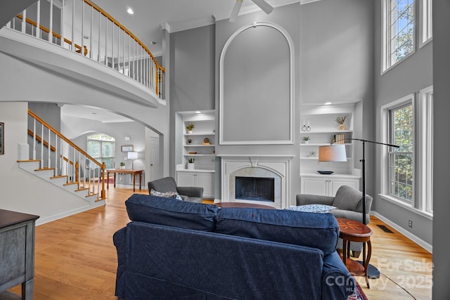 living area featuring wood finished floors, arched walkways, and a high ceiling