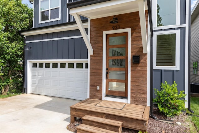 property entrance featuring driveway, board and batten siding, and a garage