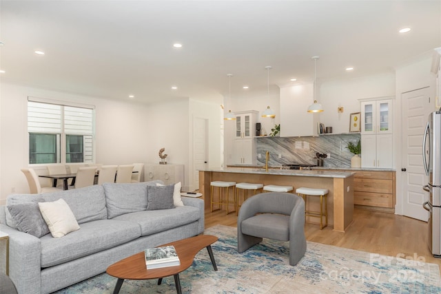 living area featuring light wood-type flooring and recessed lighting