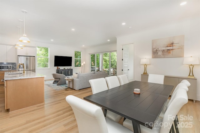 dining room with light wood finished floors, a wealth of natural light, and recessed lighting