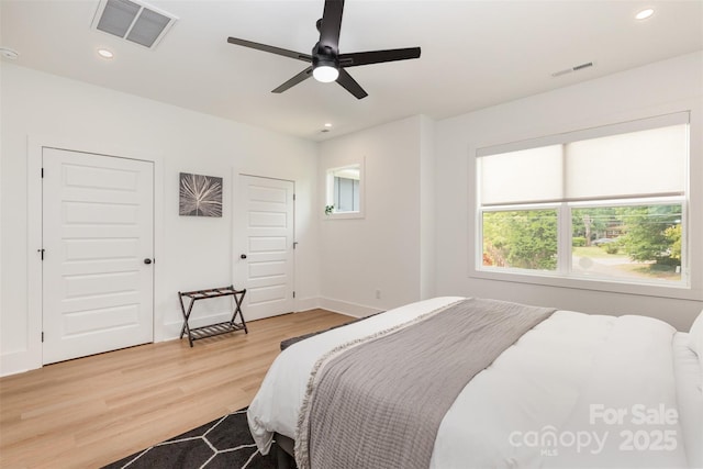 bedroom featuring baseboards, wood finished floors, visible vents, and recessed lighting