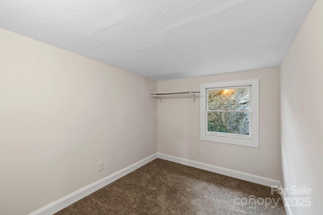 456 Newtown Rd, Rosman, NC 28772 - empty room with baseboards, dark carpet, and a textured ceiling