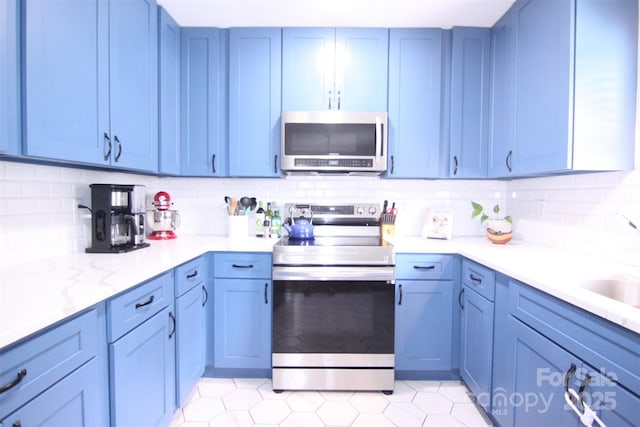 201 Mitchell St, Belmont, NC 28012 - kitchen featuring blue cabinets, light countertops, appliances with stainless steel finishes, and tasteful backsplash