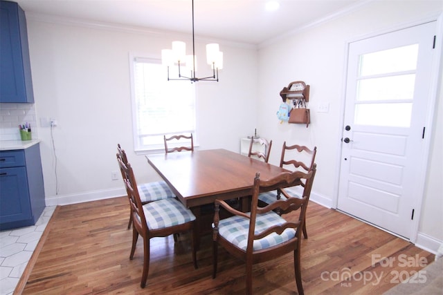201 Mitchell St, Belmont, NC 28012 - dining space featuring light wood-style flooring, crown molding, baseboards, and an inviting chandelier
