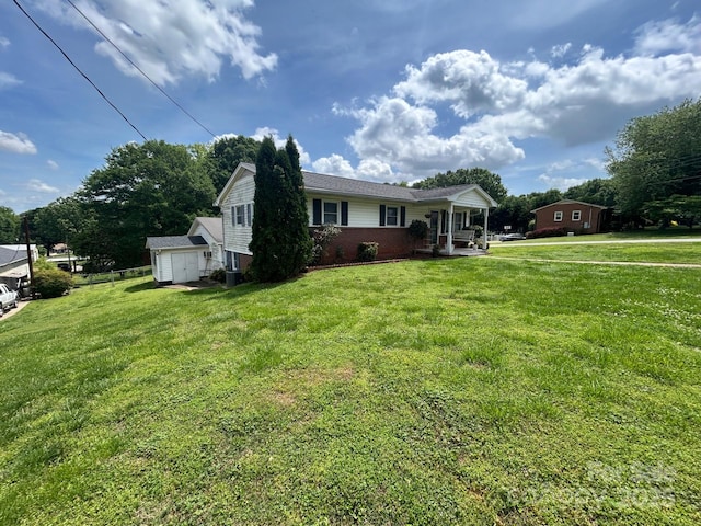 201 Mitchell St, Belmont, NC 28012 - view of front of property with a storage unit, brick siding, a front yard, and an outbuilding