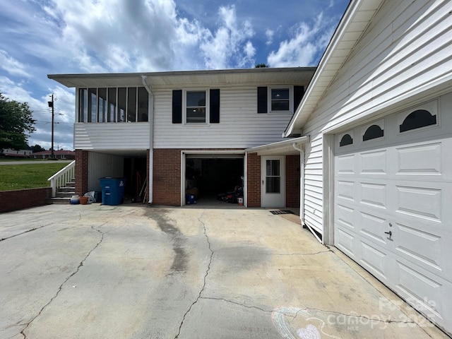 201 Mitchell St, Belmont, NC 28012 - view of front of house featuring an attached garage, a sunroom, driveway, and brick siding
