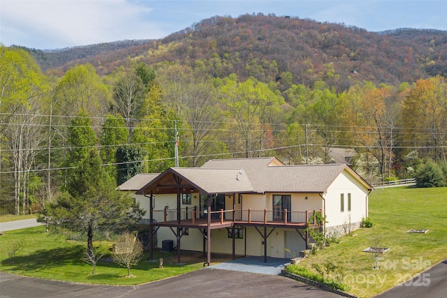 196 Timberline Dr, Maggie Valley, NC 28751 - view of front of home with a deck with mountain view, a wooded view, aphalt driveway, central AC unit, and a front yard