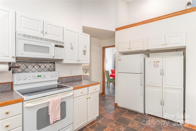 196 Timberline Dr, Maggie Valley, NC 28751 - kitchen with washing machine and dryer, stone finish flooring, backsplash, white cabinetry, and white appliances