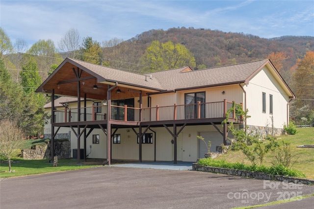196 Timberline Dr, Maggie Valley, NC 28751 - view of front of home with aphalt driveway, roof with shingles, central air condition unit, a deck with mountain view, and a ceiling fan