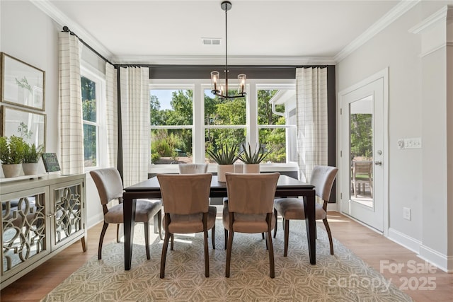 424 Balboa St, Matthews, NC 28104 - dining area with ornamental molding, a chandelier, and wood finished floors