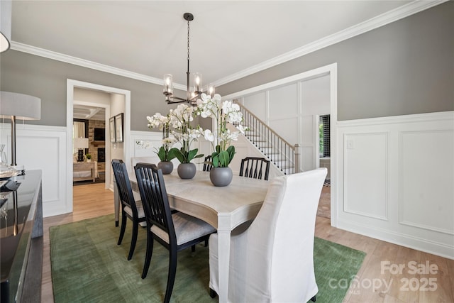 424 Balboa St, Matthews, NC 28104 - dining room featuring a decorative wall, wood finished floors, crown molding, a chandelier, and wainscoting