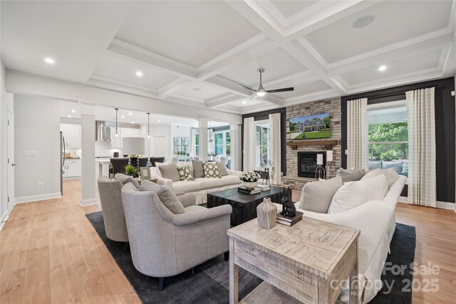 424 Balboa St, Matthews, NC 28104 - living room featuring light wood-style flooring, coffered ceiling, beam ceiling, ceiling fan, and a fireplace