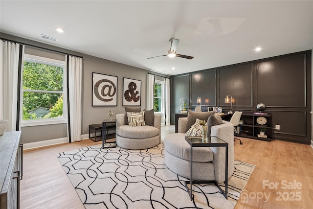 424 Balboa St, Matthews, NC 28104 - living area featuring light wood-style floors, a ceiling fan, a decorative wall, and recessed lighting
