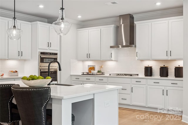 424 Balboa St, Matthews, NC 28104 - kitchen with wall chimney exhaust hood, appliances with stainless steel finishes, a kitchen bar, decorative backsplash, and white cabinetry