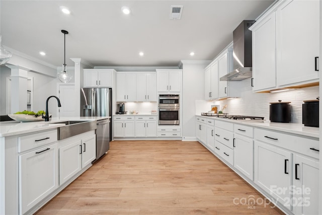424 Balboa St, Matthews, NC 28104 - kitchen featuring appliances with stainless steel finishes, wall chimney exhaust hood, crown molding, decorative backsplash, and white cabinets