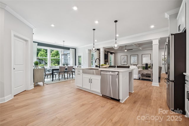 424 Balboa St, Matthews, NC 28104 - kitchen featuring appliances with stainless steel finishes, open floor plan, crown molding, light wood-type flooring, and light countertops