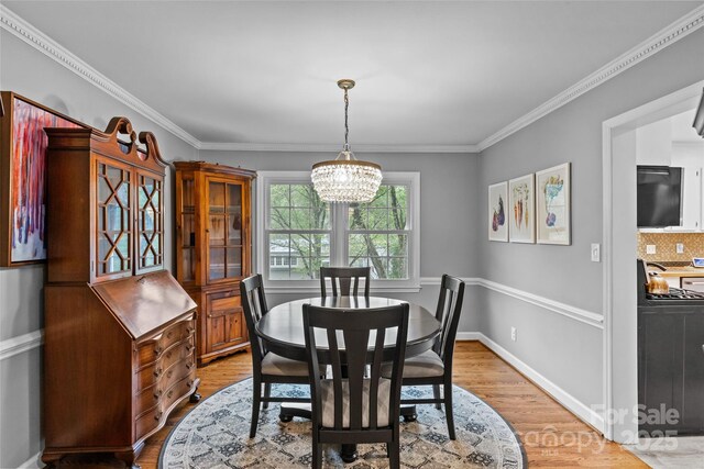 2418 Ainsdale Rd, Charlotte, NC 28226 - dining room featuring light wood finished floors, a chandelier, crown molding, and baseboards