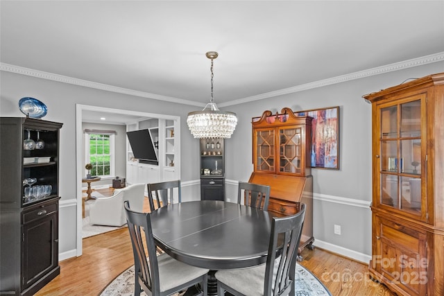 2418 Ainsdale Rd, Charlotte, NC 28226 - dining room featuring light wood-style flooring, crown molding, a chandelier, and baseboards