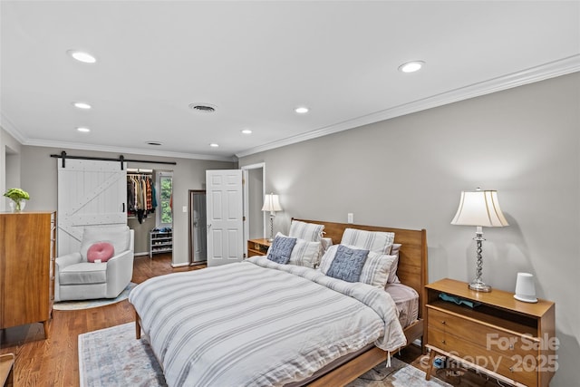 2418 Ainsdale Rd, Charlotte, NC 28226 - bedroom featuring a barn door, recessed lighting, crown molding, a closet, and wood finished floors