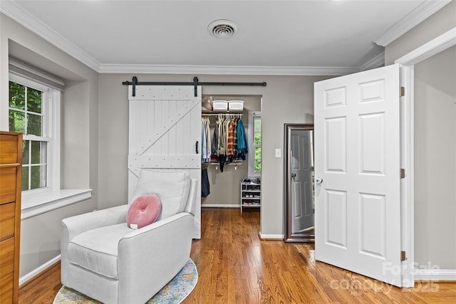 2418 Ainsdale Rd, Charlotte, NC 28226 - living area with crown molding, wood finished floors, plenty of natural light, baseboards, and a barn door