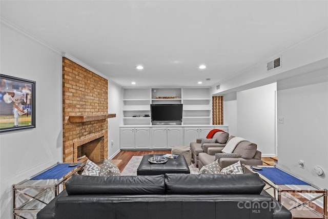2418 Ainsdale Rd, Charlotte, NC 28226 - living area with wood finished floors, crown molding, a brick fireplace, recessed lighting, and baseboards